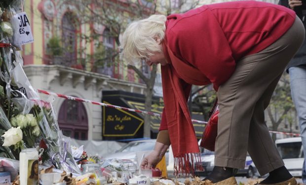 An elderly woman lights up a candle a makeshift memorial next to the Bataclan concert hall in Paris. (Photo: AP) An elderly woman lights up a candle a makeshift memorial next to the Bataclan concert hall in Paris. (Photo: AP)